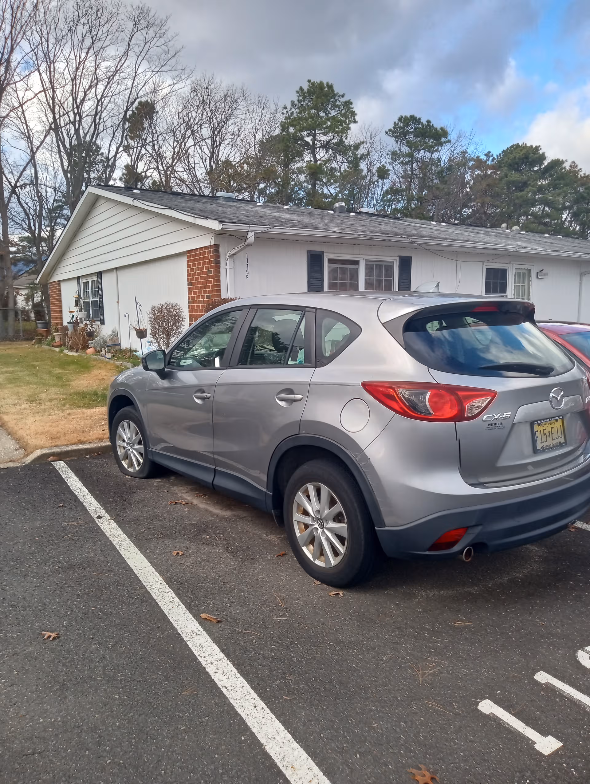 Silver Mazda SUV parked in front of a single-story senior living building.