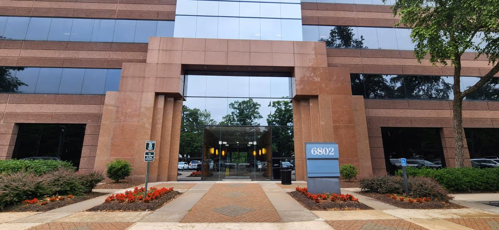 Modern brick building with a glass entrance and landscaped front walkway