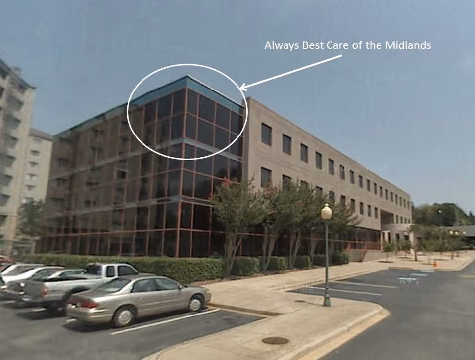Exterior view of Always Best Care facility with glass facade and surrounding parking.