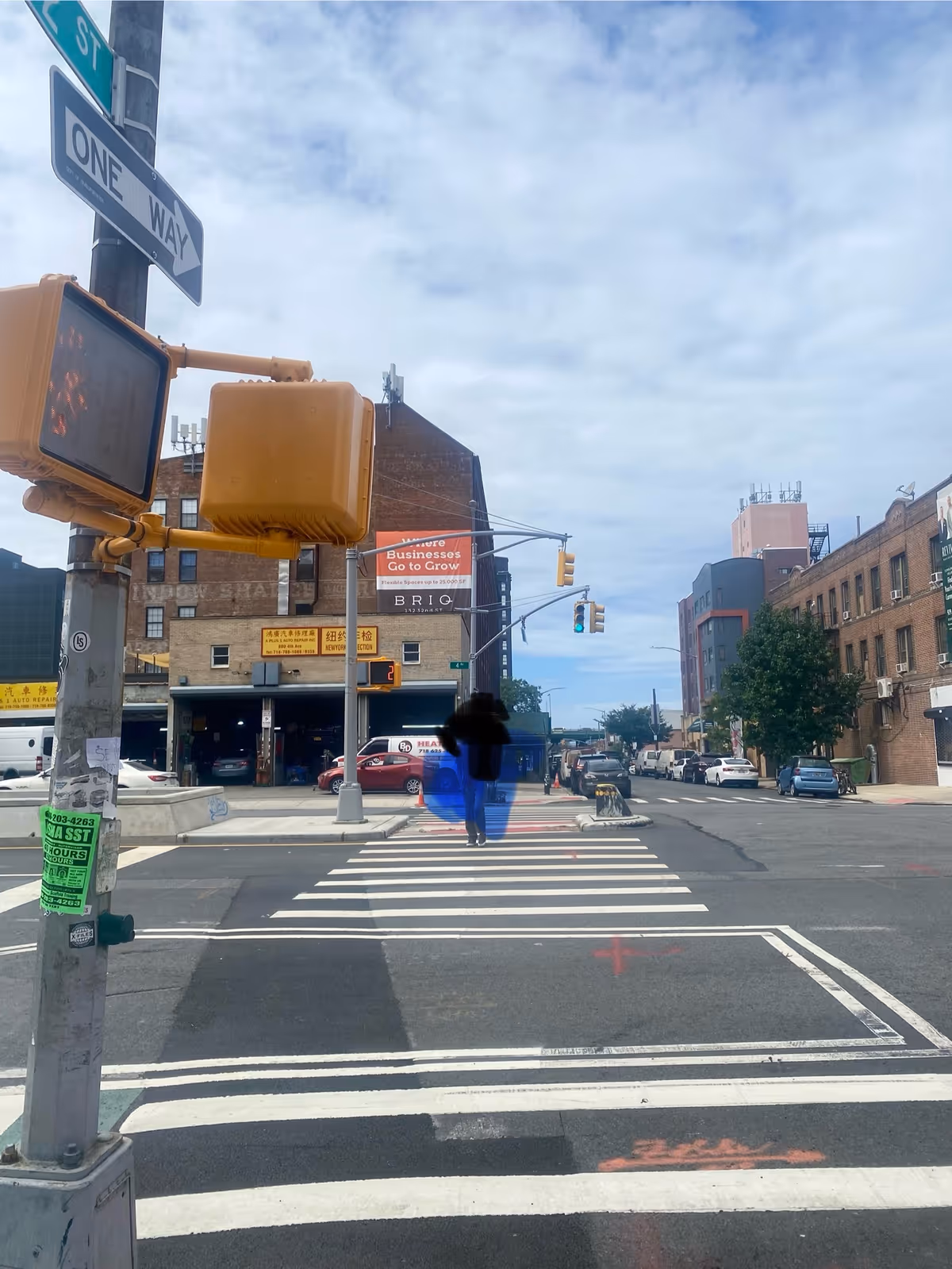 Urban crosswalk at a city intersection with brick buildings and traffic signals