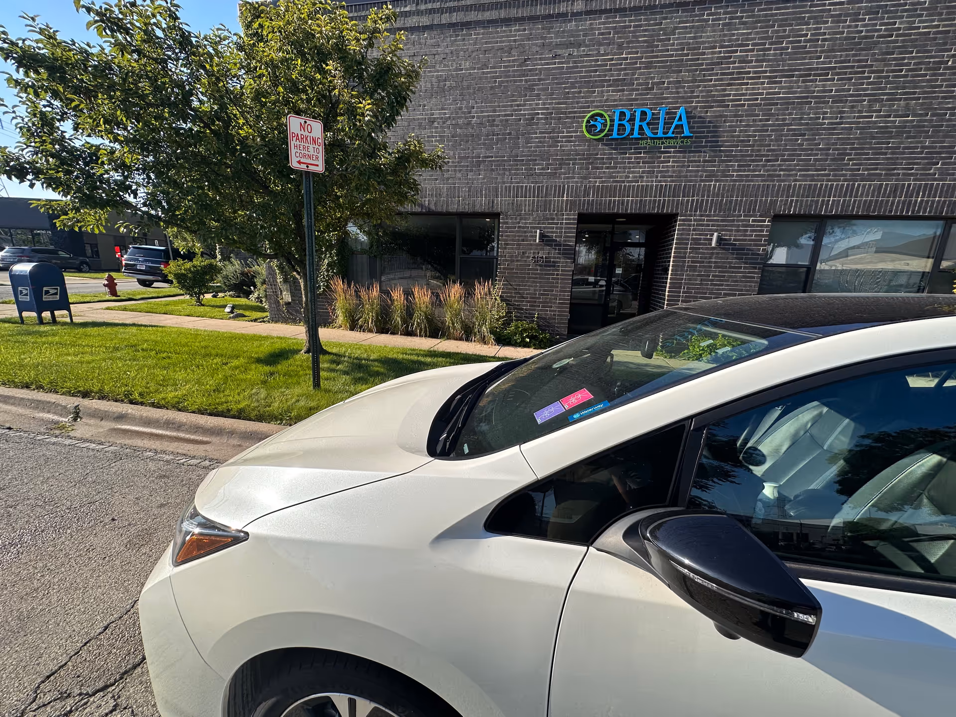 Front exterior of BRIA Health Services building with a white car parked in foreground.