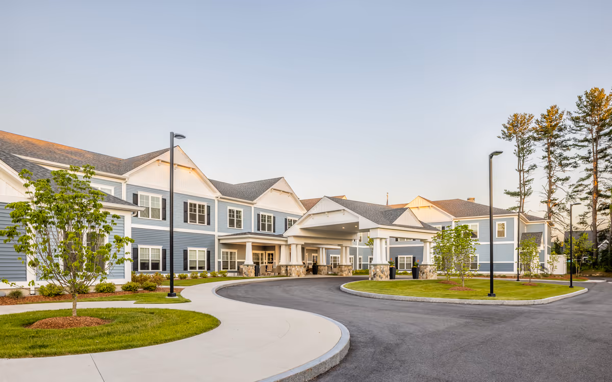 Blue two-story senior living facility with circular driveway and covered entrance.