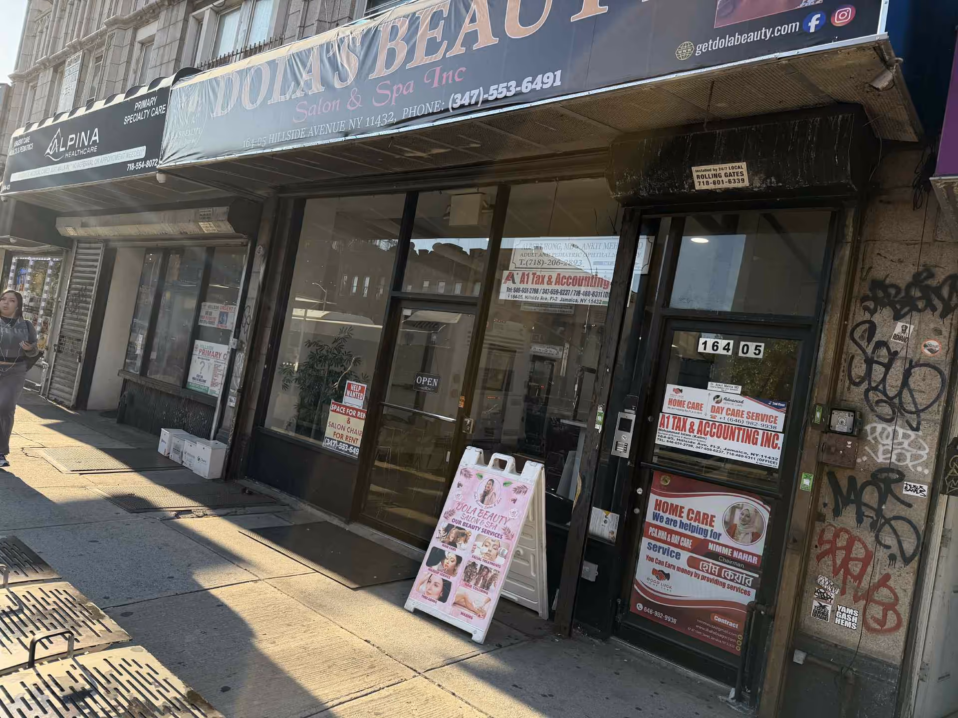 Urban storefront with beauty salon signage and posters on the windows.