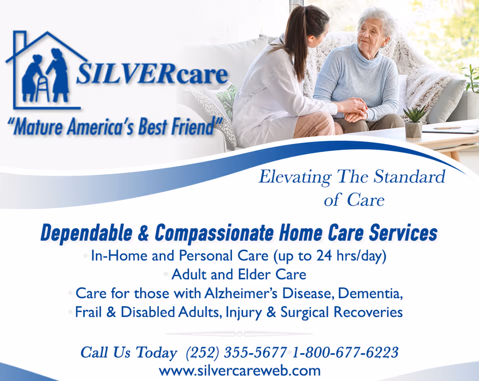 A caregiver chats with an elderly woman in a cozy living room beside a SILVERcare banner.