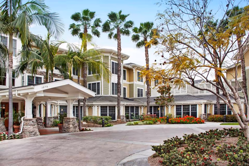 Exterior view of Ivy Park at Seal Beach, showing a covered entrance and palm trees.