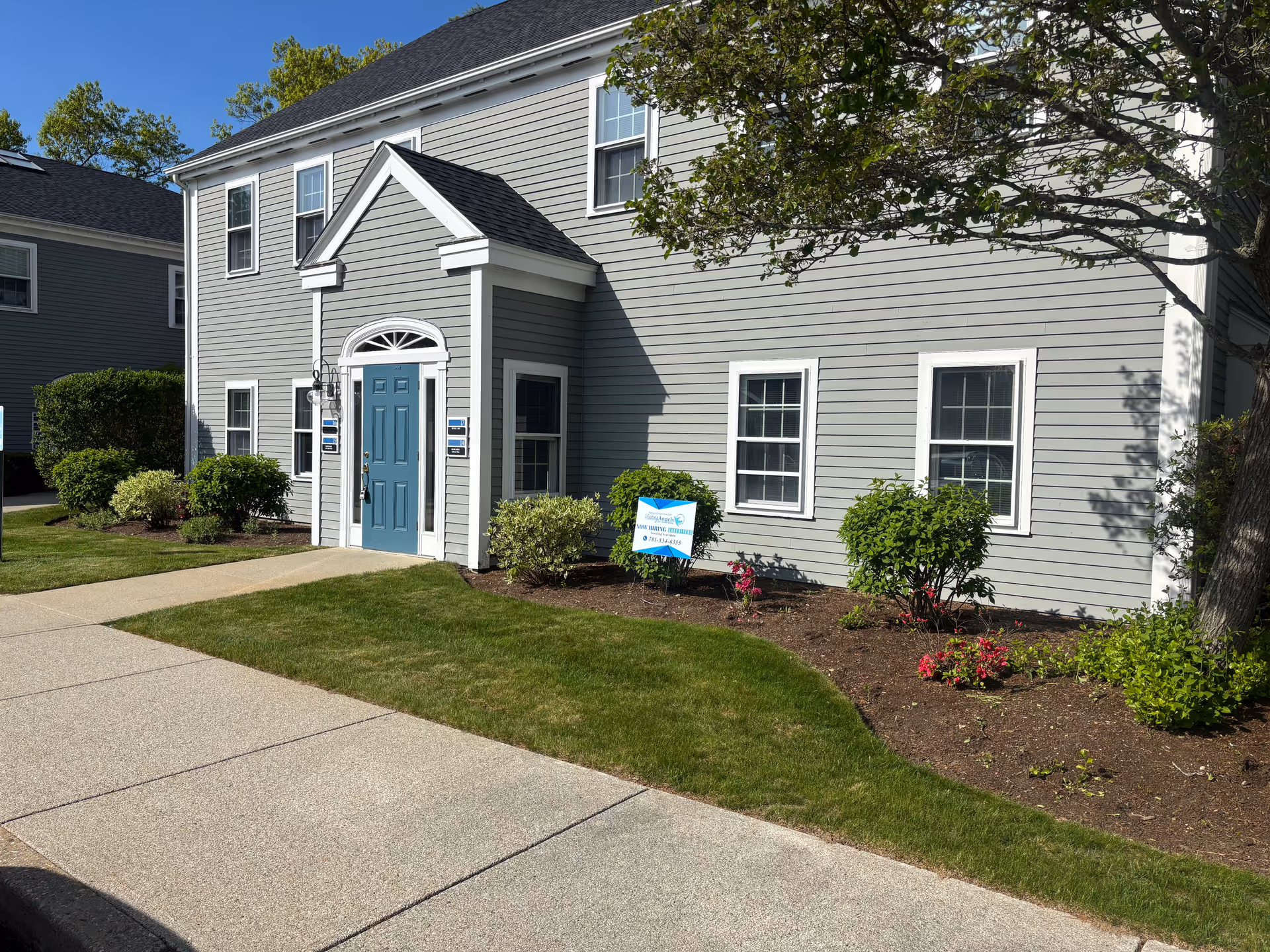 Exterior view of Visiting Angels senior home care building with a blue door.