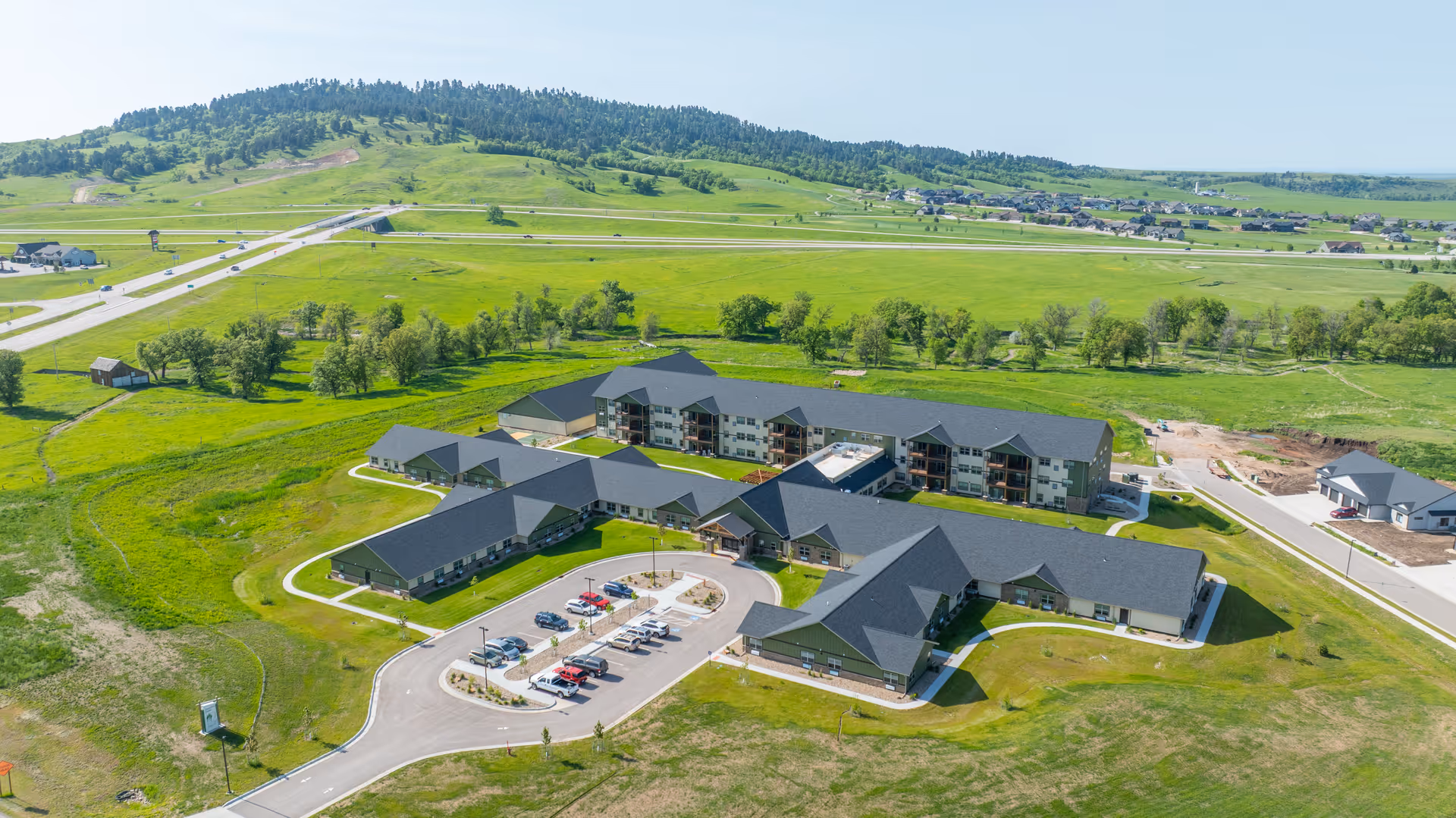 Aerial view of Peaceful Pines Senior Living campus with green fields.