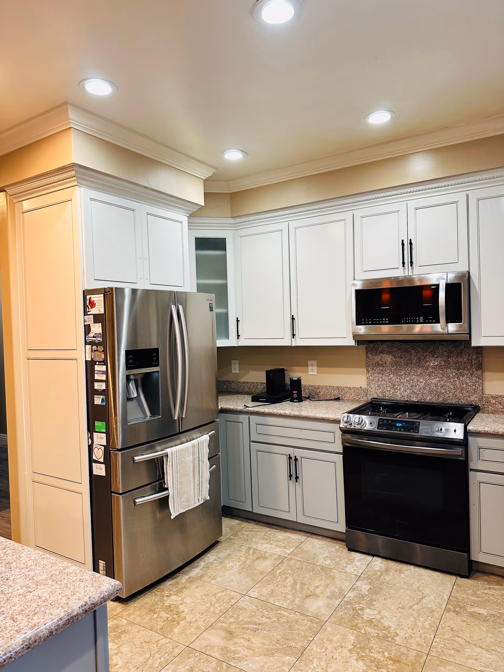 Modern kitchen with stainless steel appliances and white cabinetry in a senior residence.