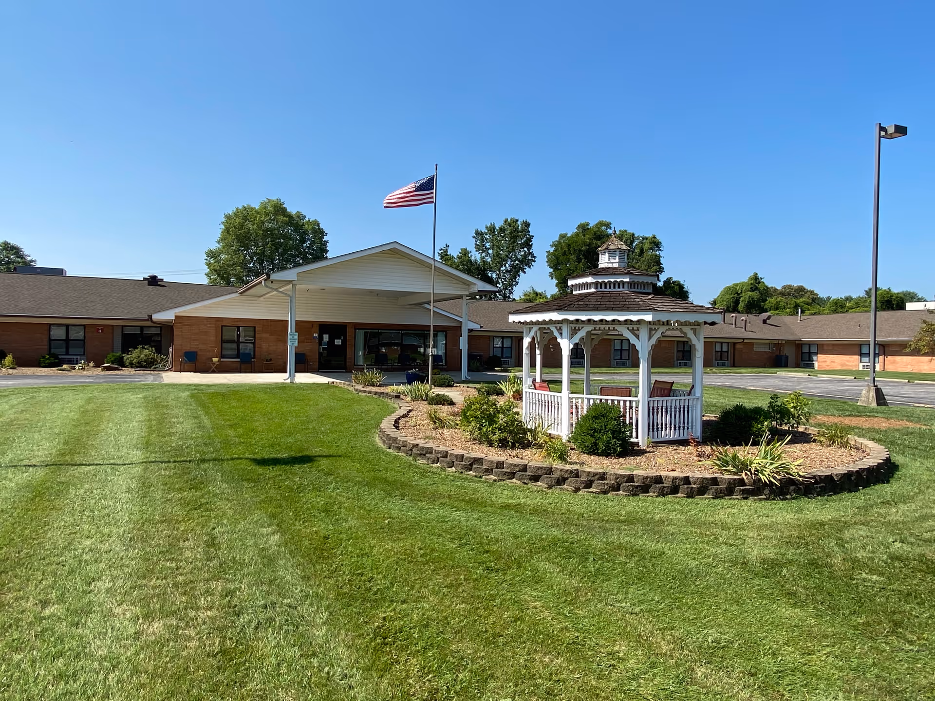 Exterior view of Golden LivingCenter with a gazebo, flagpole, and well-kept lawn.