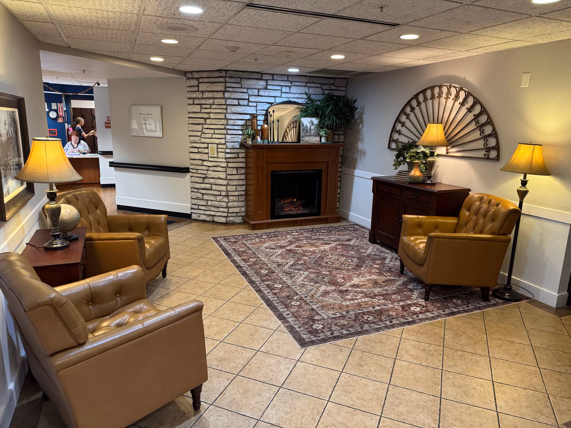 Cozy interior lobby of a senior living facility with leather chairs and a fireplace.