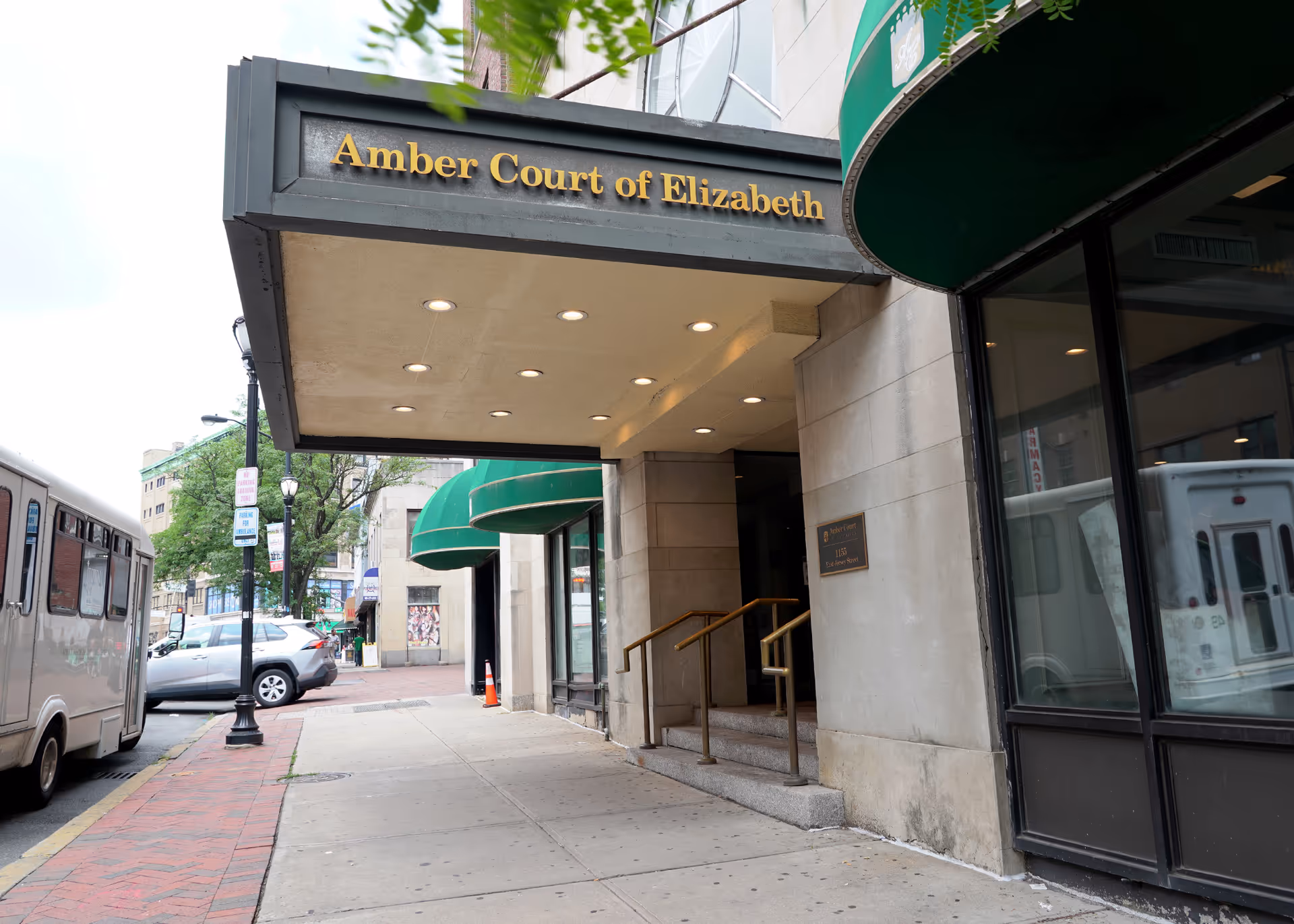 Front view of Amber Court of Elizabeth entrance with sidewalk, awnings, and street scene.