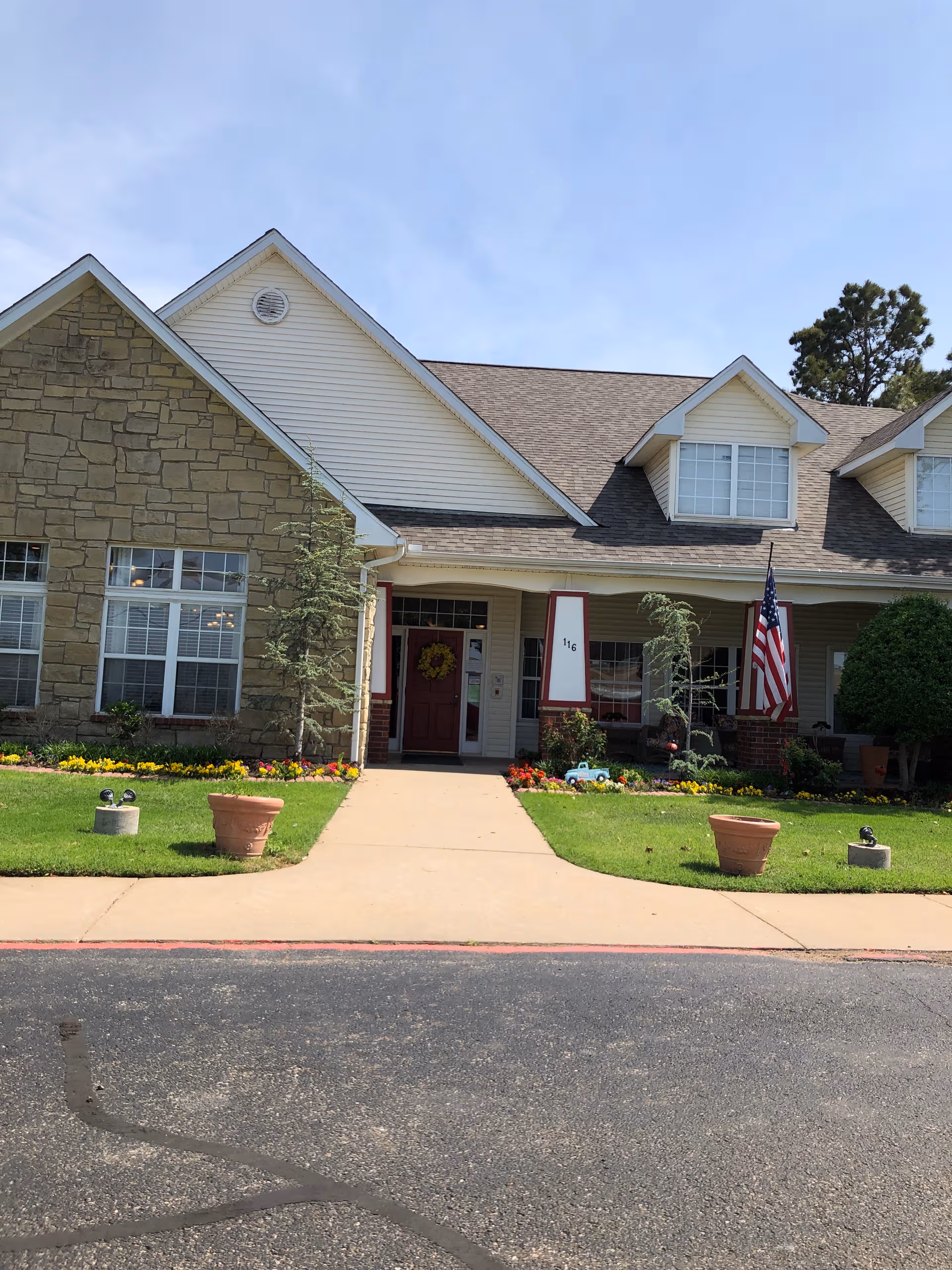 Exterior view of Brookdale Edmond Danforth front entrance with landscaping and flag.