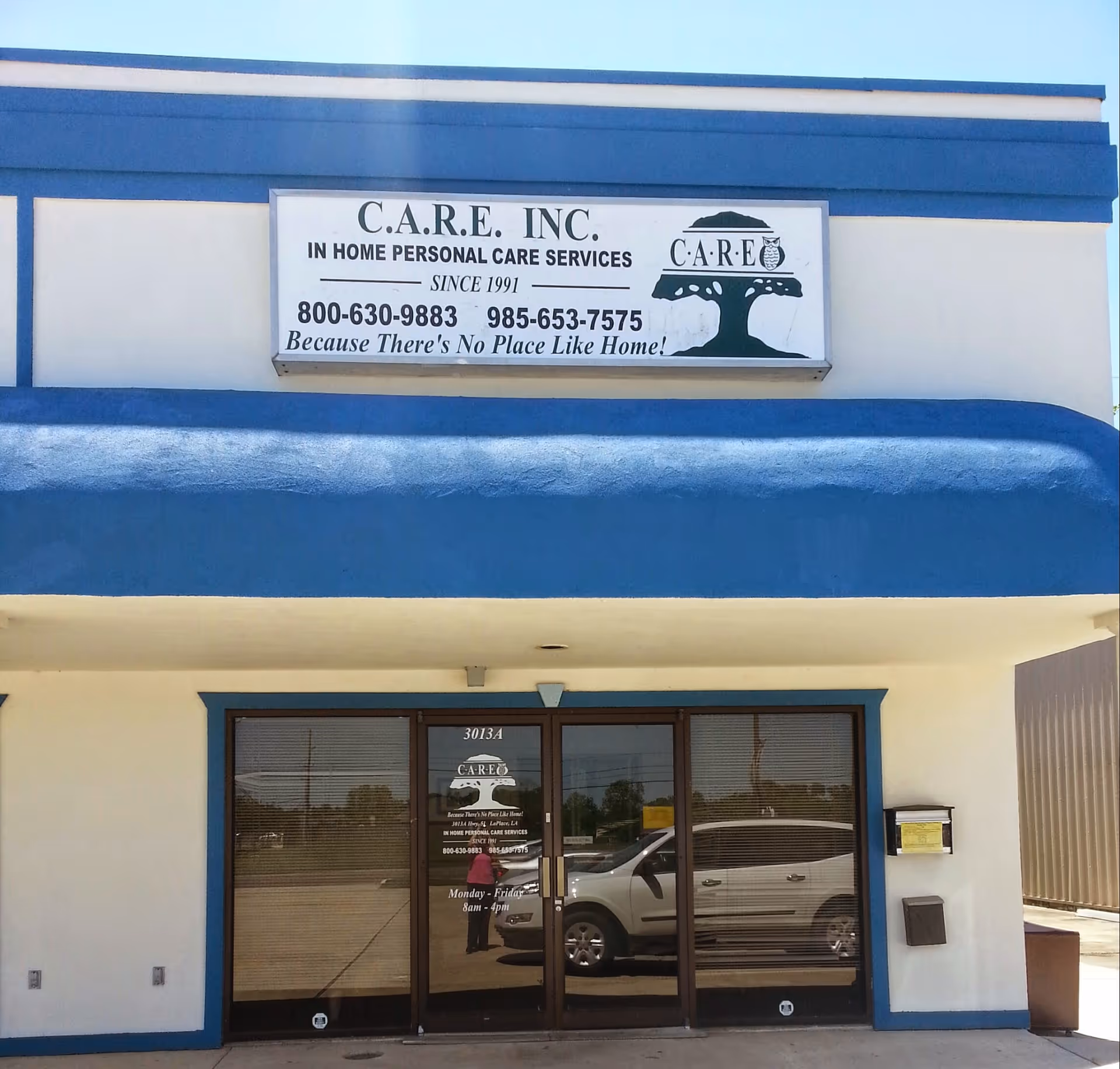 Front view of CARE, Inc. storefront with sign, blue awning, and glass entrance.