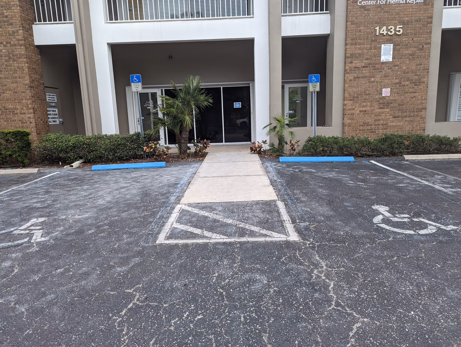 Front entrance of a senior living facility with handicap parking and landscaped walkway.
