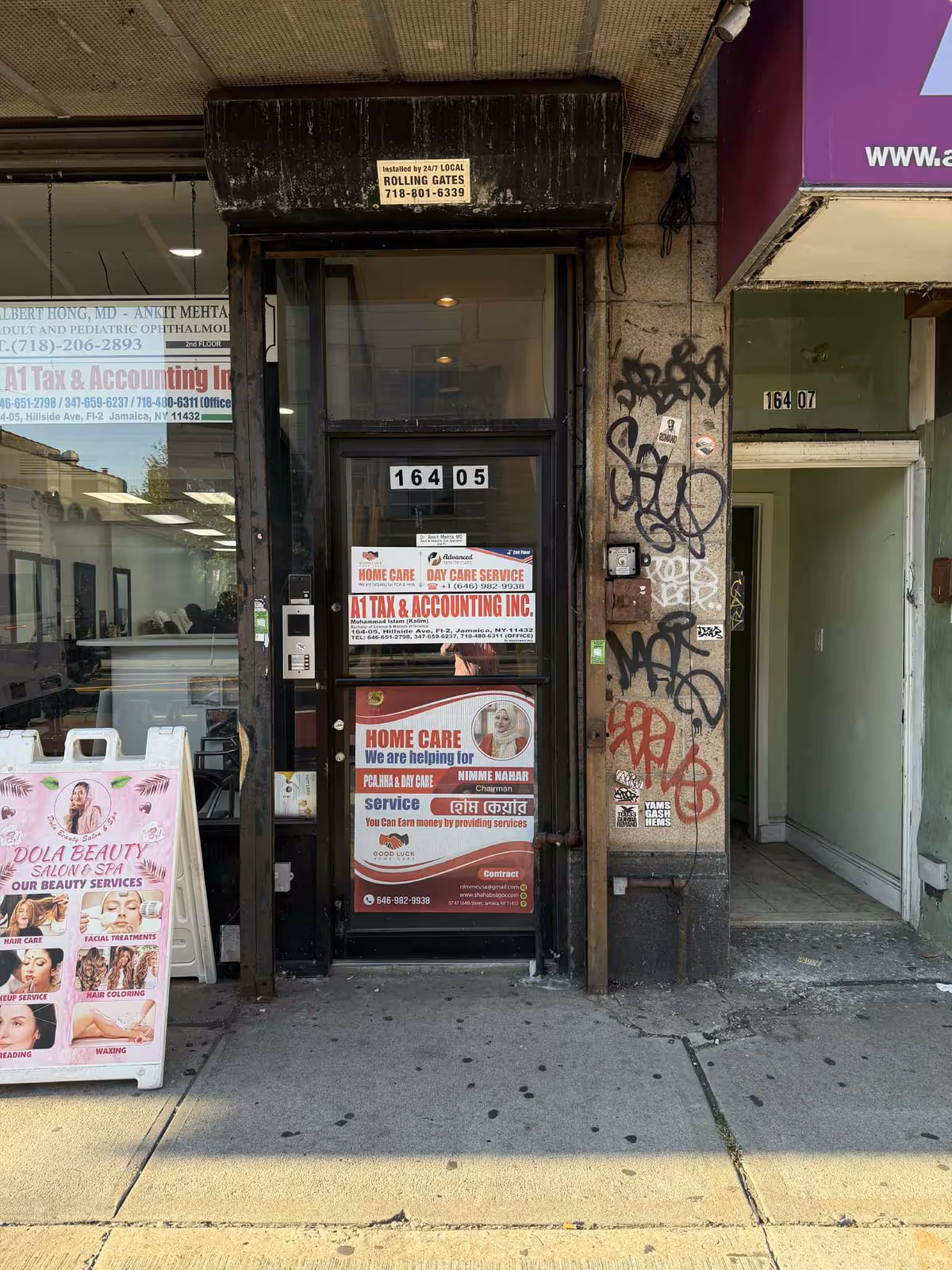 Storefront with posters advertising Good Luck Home Care; graffiti on wall beside a glass door.