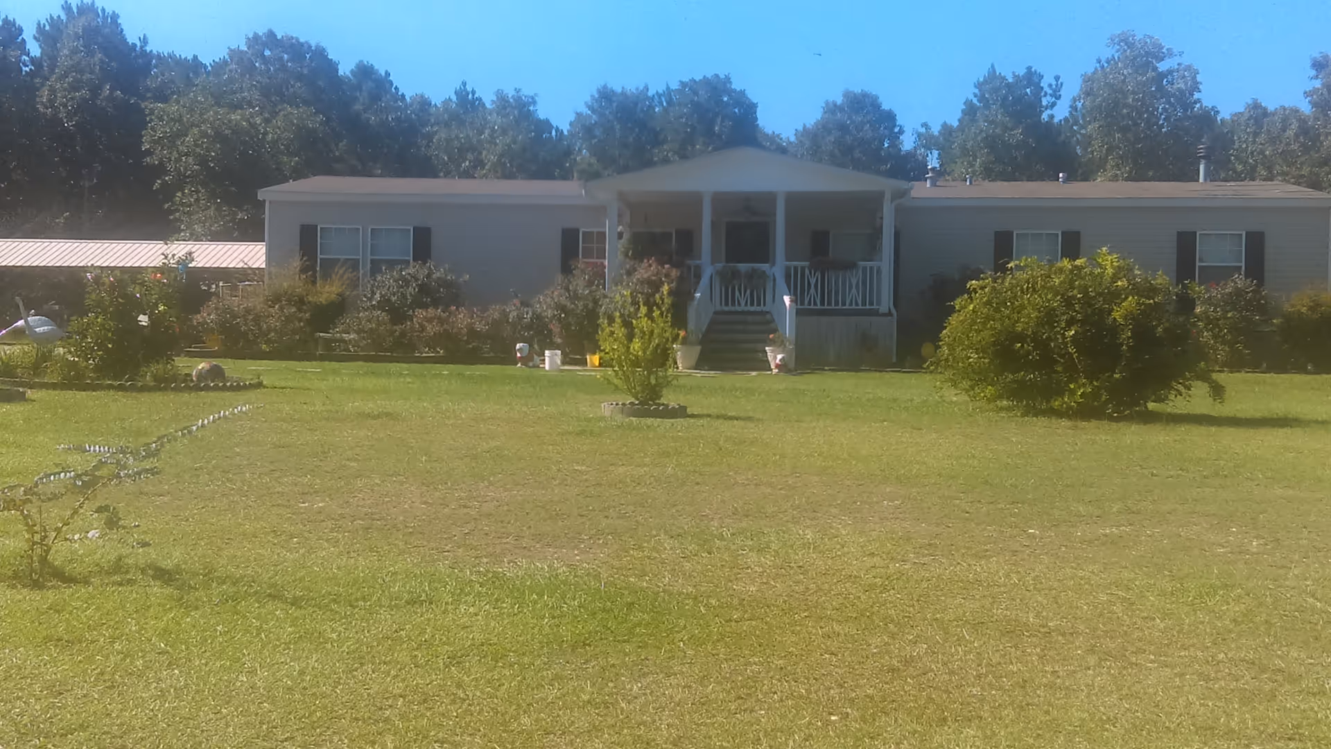 Front view of C R Neeley senior living facility with porch and lawn