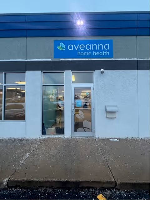 Exterior view of Aveanna Home Health facility entrance with glass doors and sign.
