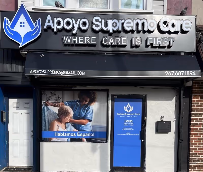 Front view of Apoyo Supremo Care storefront with logo, slogan, window ad, and blue door.