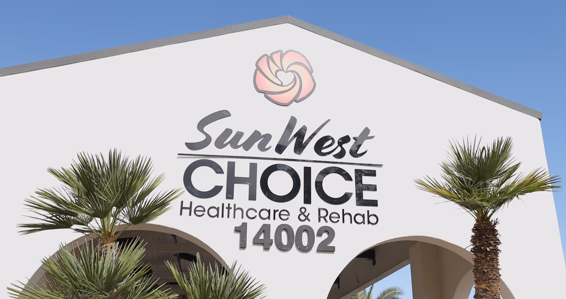 Front exterior of Sun West Choice Healthcare & Rehab with palm trees and sign.