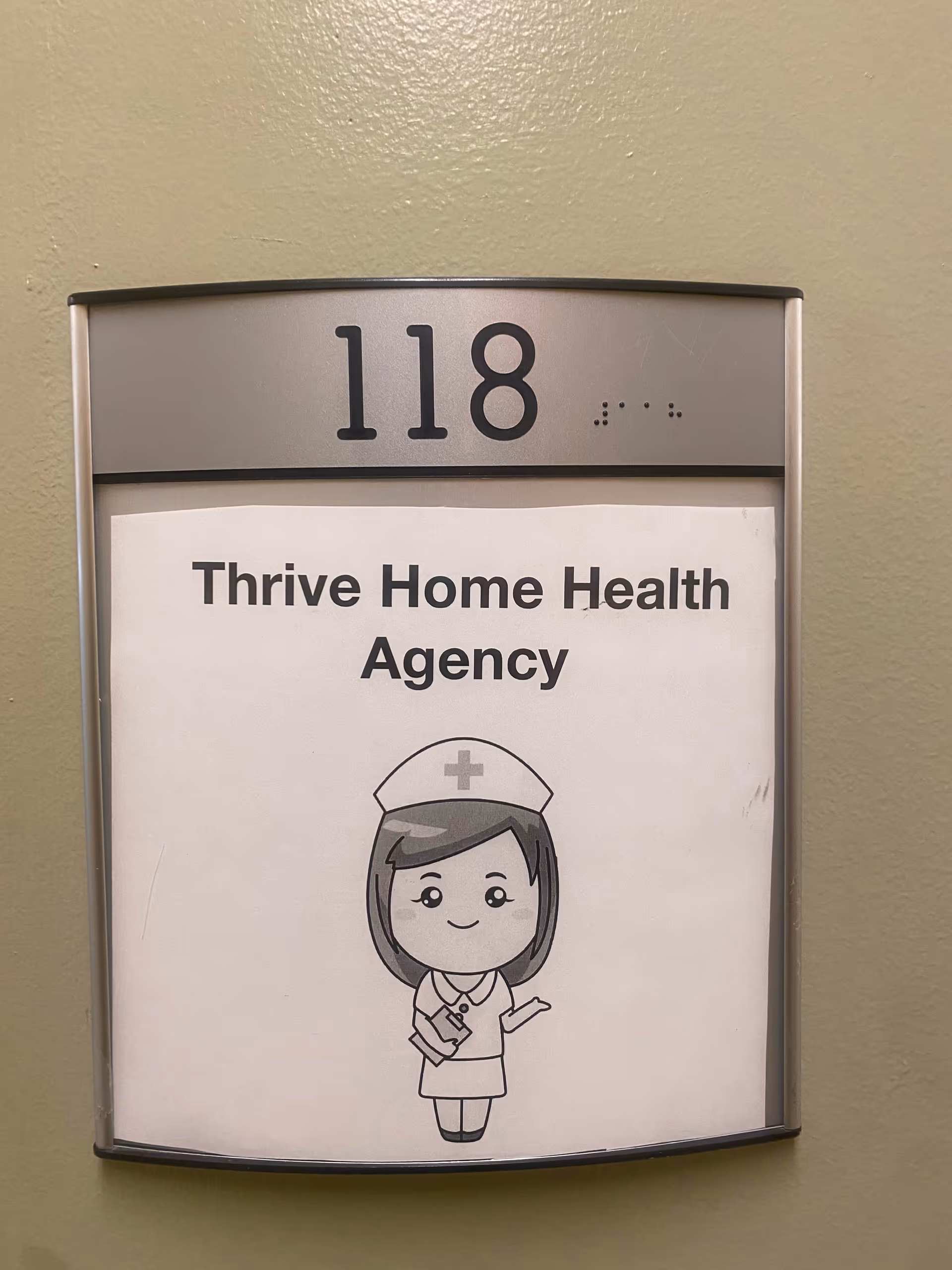Hallway wall sign with unit 118 and Thrive Home Health Agency poster.
