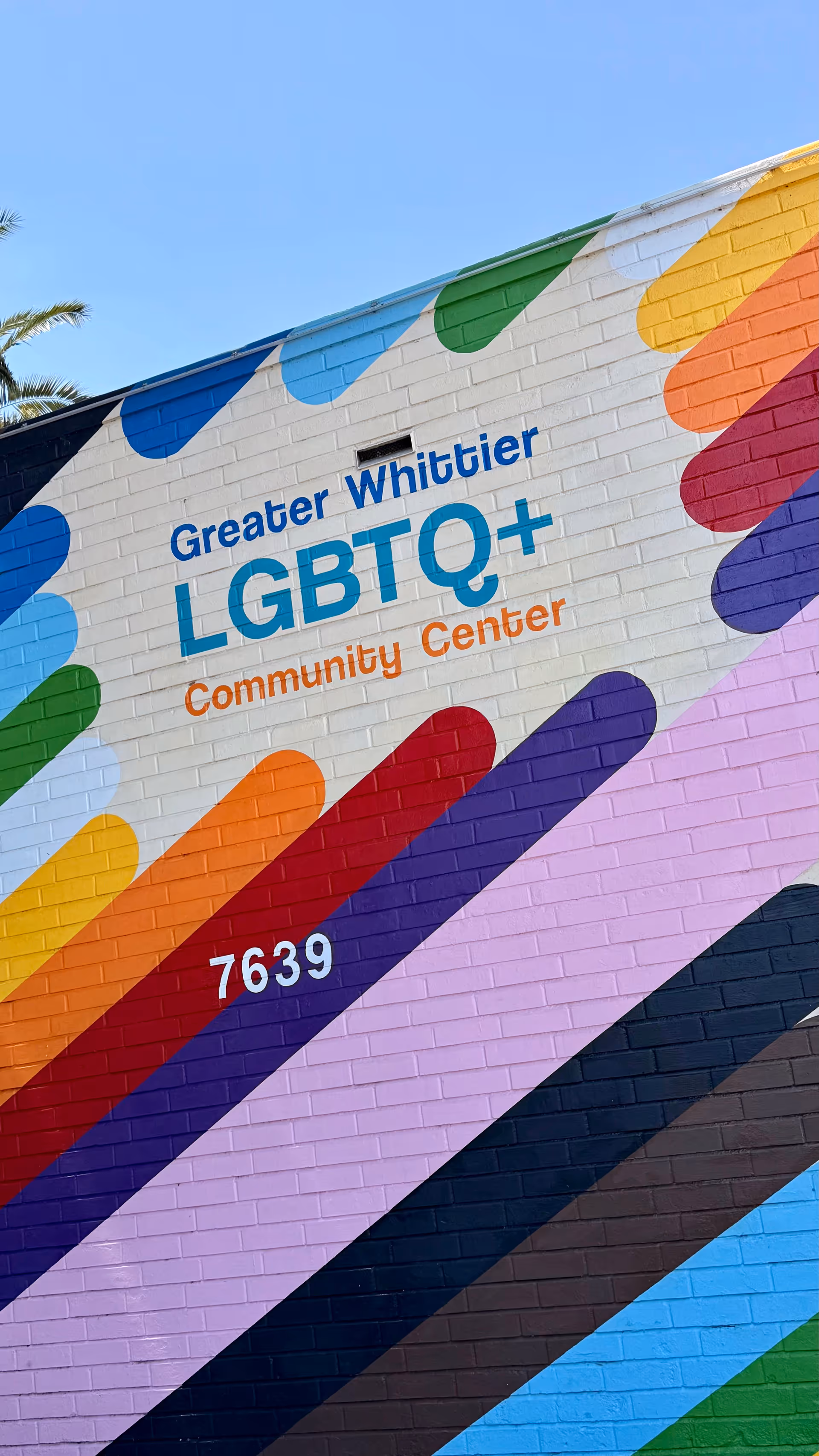 Colorful mural on brick exterior with Greater Whittier LGBTQ+ Community Center sign.