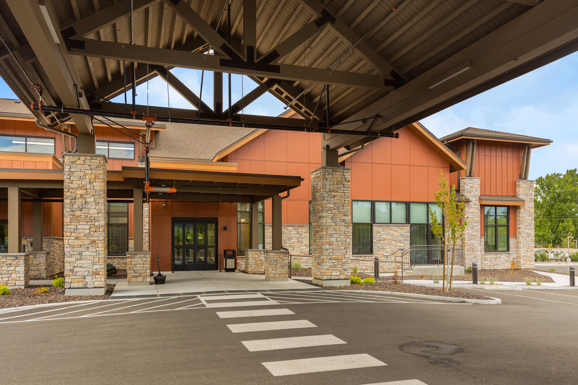 Exterior view of Sierra Basin Memory Care entrance with stone columns and canopy.