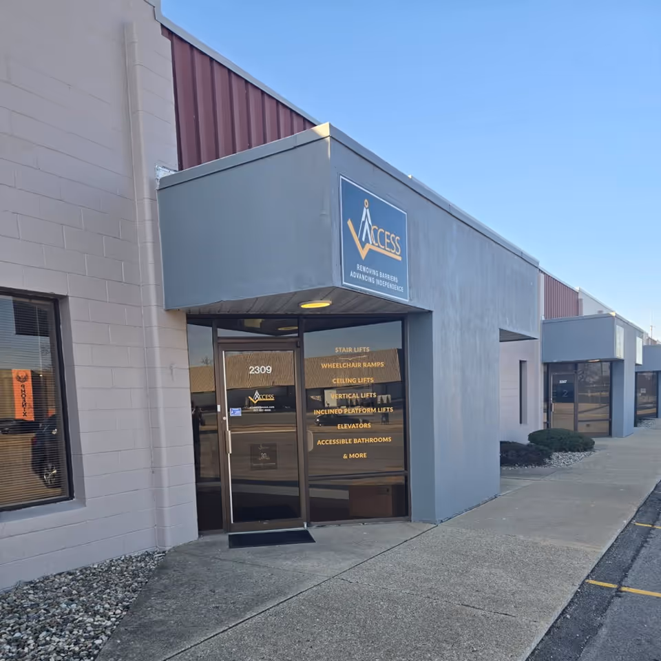 Exterior view of Access Elevator storefront with blue sign and glass door 2309.