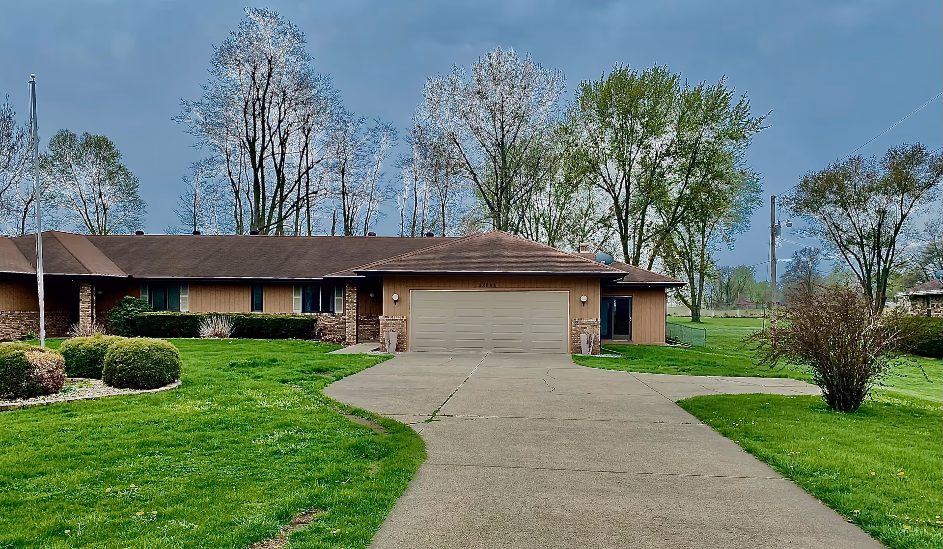 Front view of a single-story senior living facility with a driveway and green lawn.