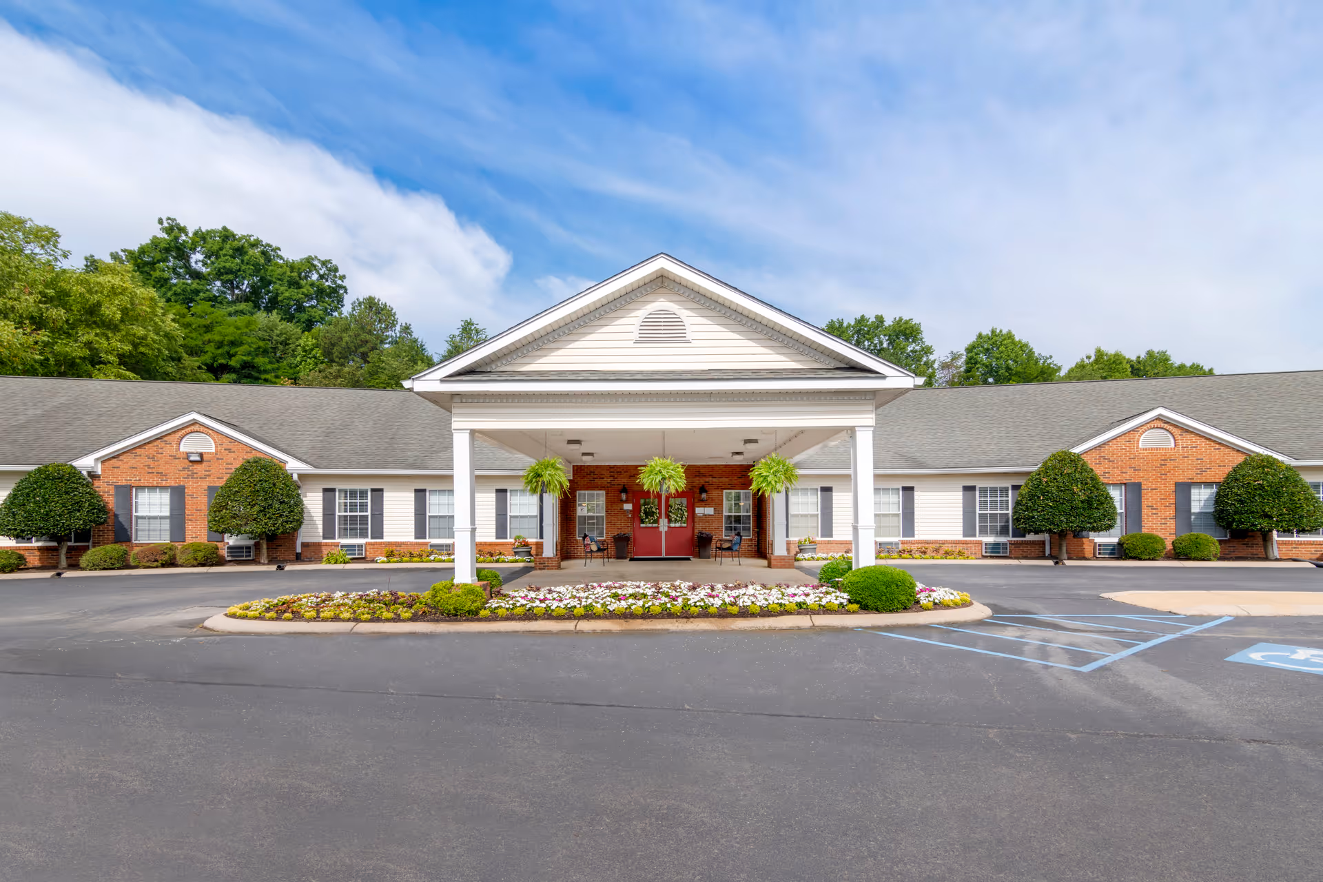 A single-story senior living facility with a covered entrance and manicured landscaping.