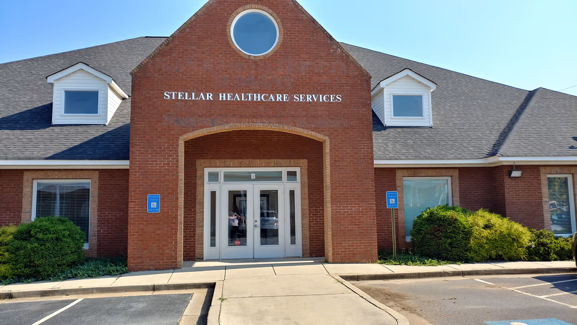 Brick facility exterior with a central entrance and Stellar Healthcare Services sign.
