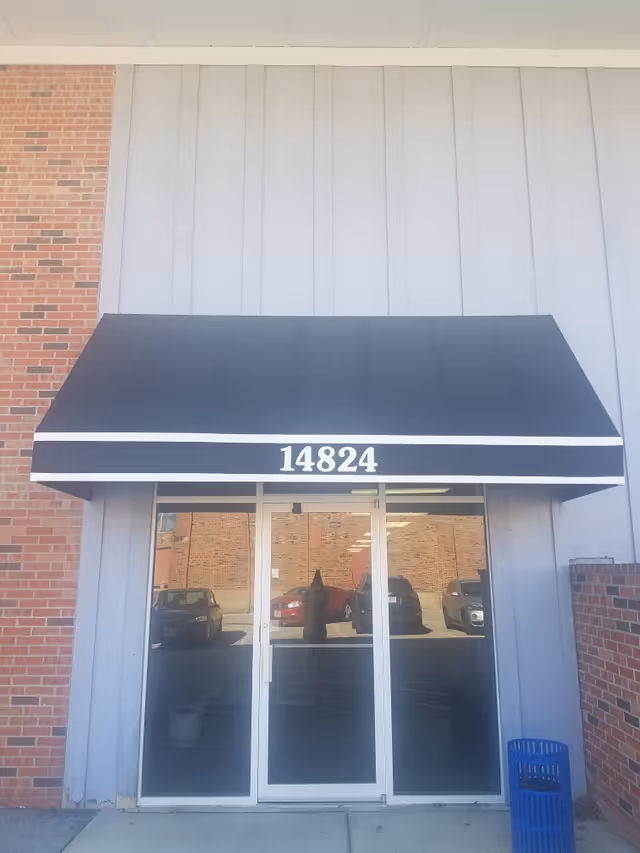 Front entrance features glass doors, a blue awning, and the address 14824.