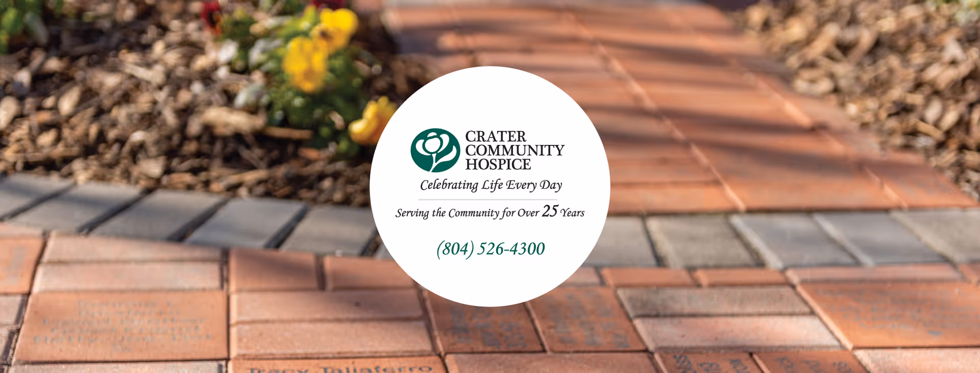 Crater Community Hospice logo on outdoor brick walkway with flowers