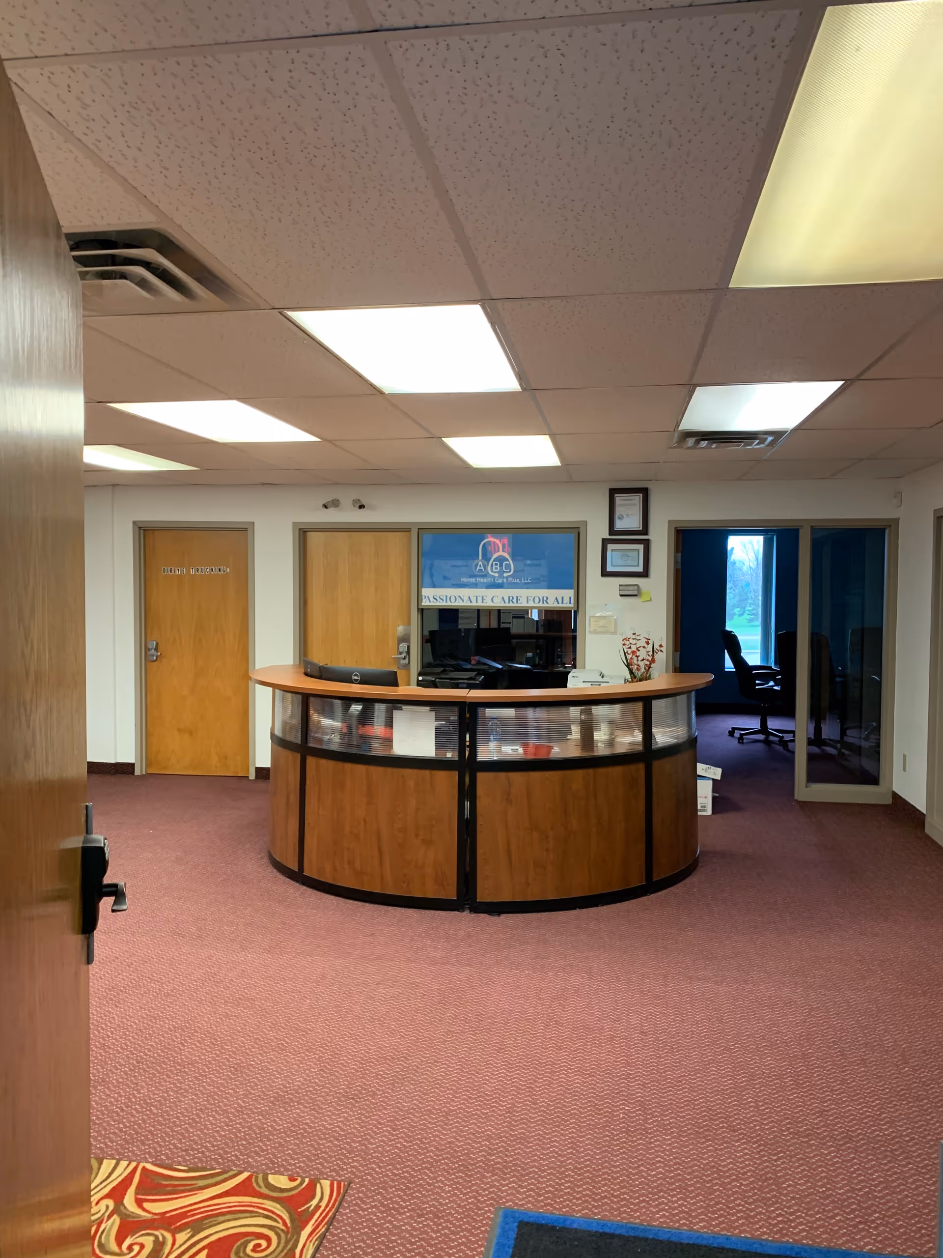 Curved reception desk in a lobby of ABC Home Health Care Plus, LLC.