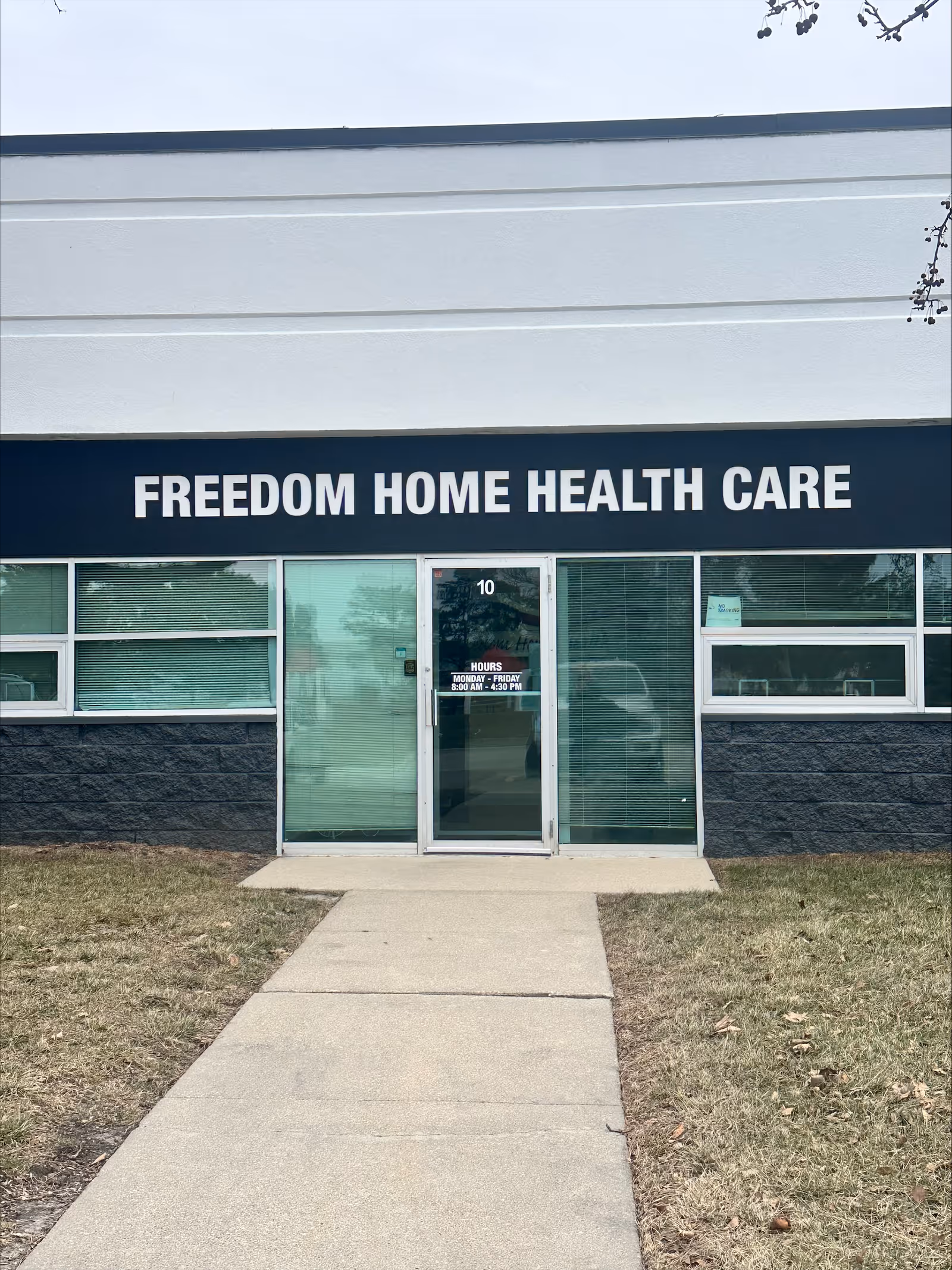 Front exterior of Freedom Home Health Care storefront with glass doors and walkway.