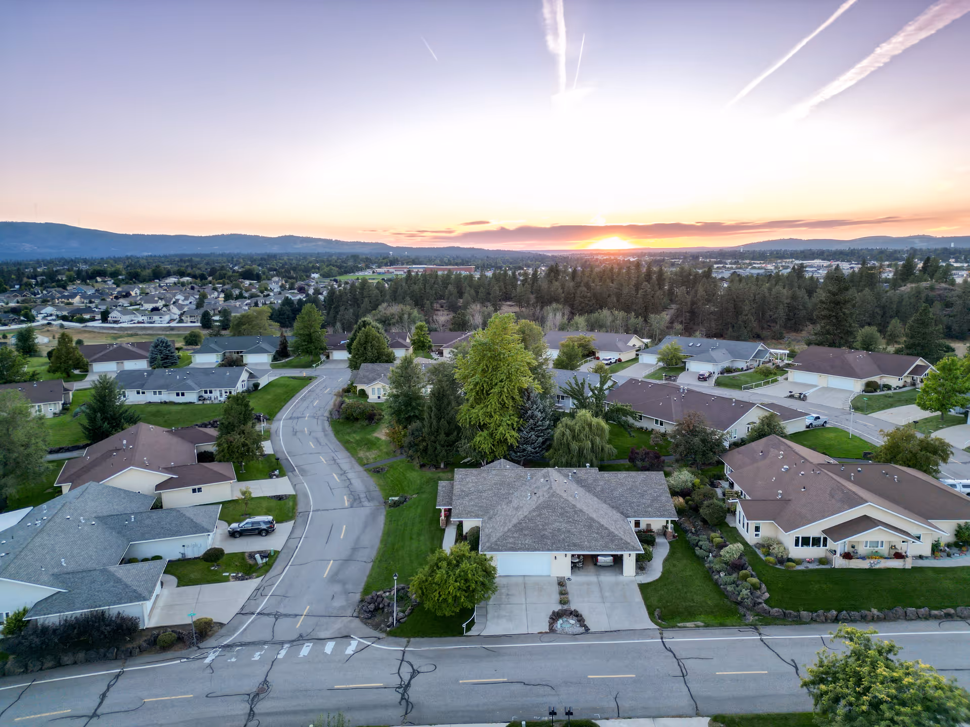 Aerial view of a sunrise over a suburban neighborhood with many homes.