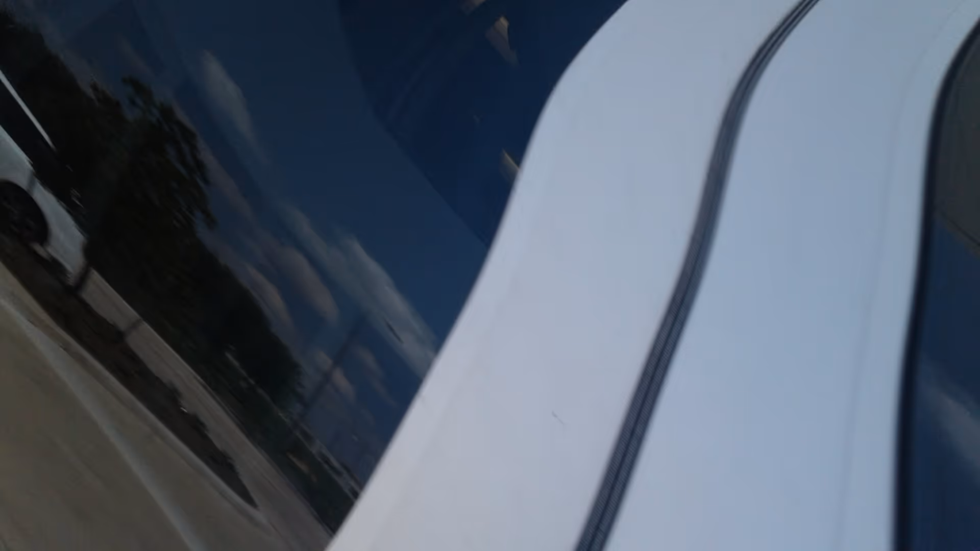 Close-up of a blue and white vehicle exterior with chrome trim.