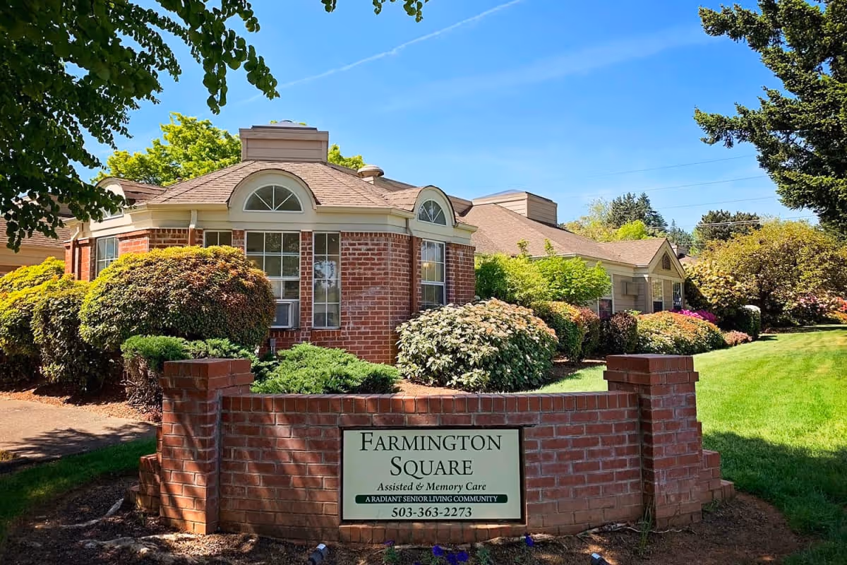 Brick-faced senior living building with landscaped grounds and a 'Farmington Square' sign in front.