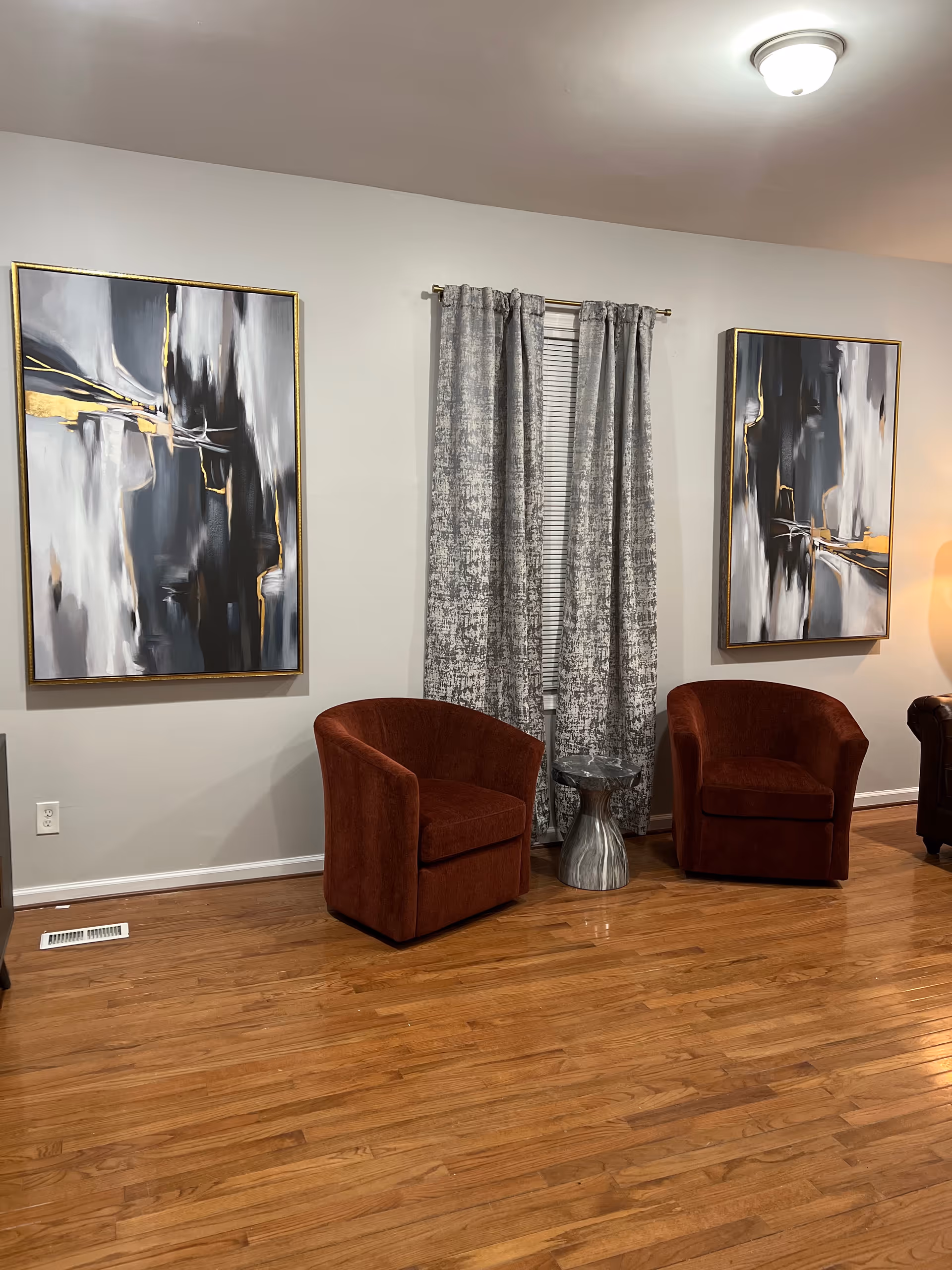 Two red armless chairs flank a small metallic table in a calm lounge area.