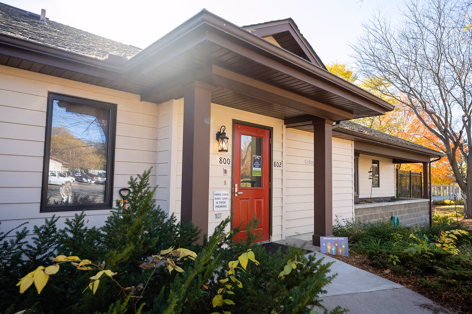 Front entrance of Cottage West by Three Links, a single-story building with a red door.