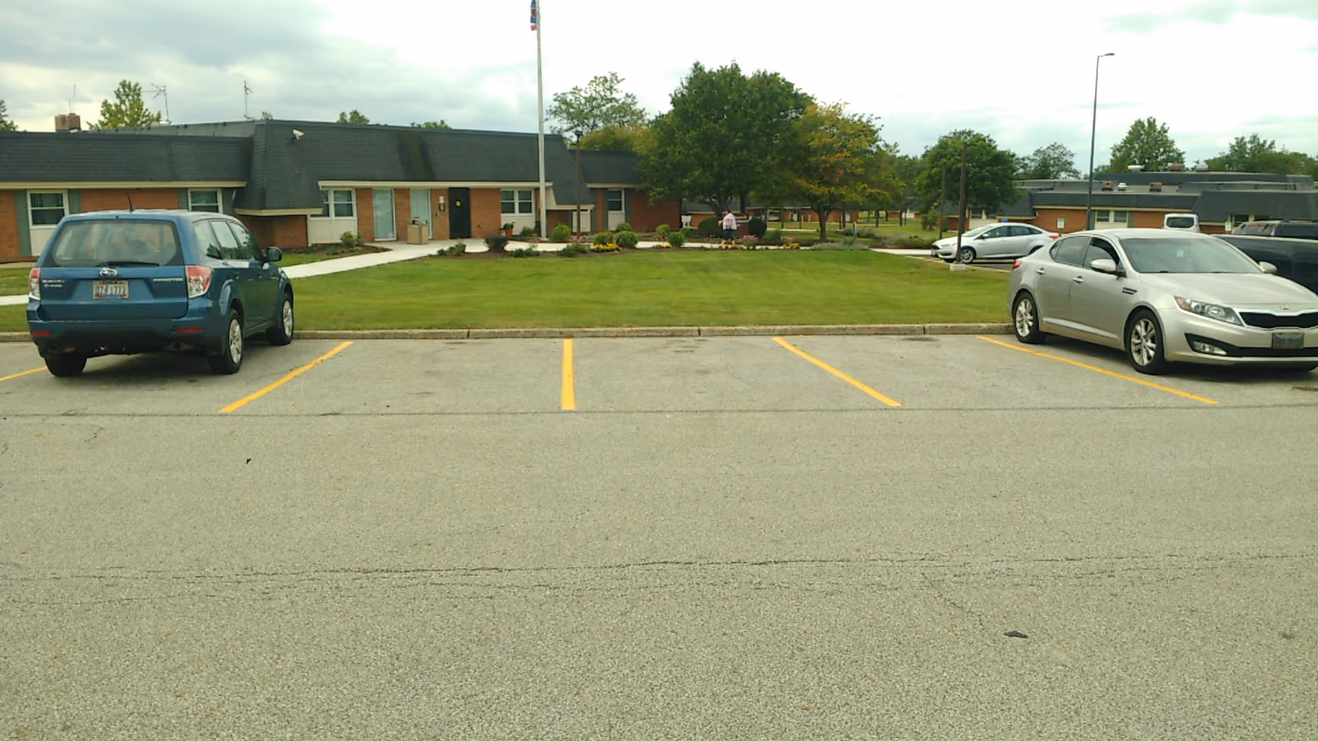 Exterior view of Warrensville Developmental Center with a parking lot and manicured lawn.