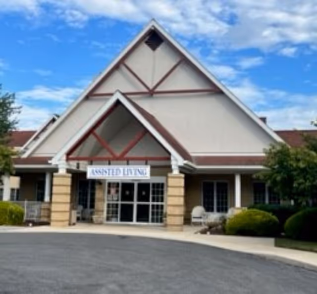 Exterior view of Creekside Residences entrance with peaked roof and assisted living sign.