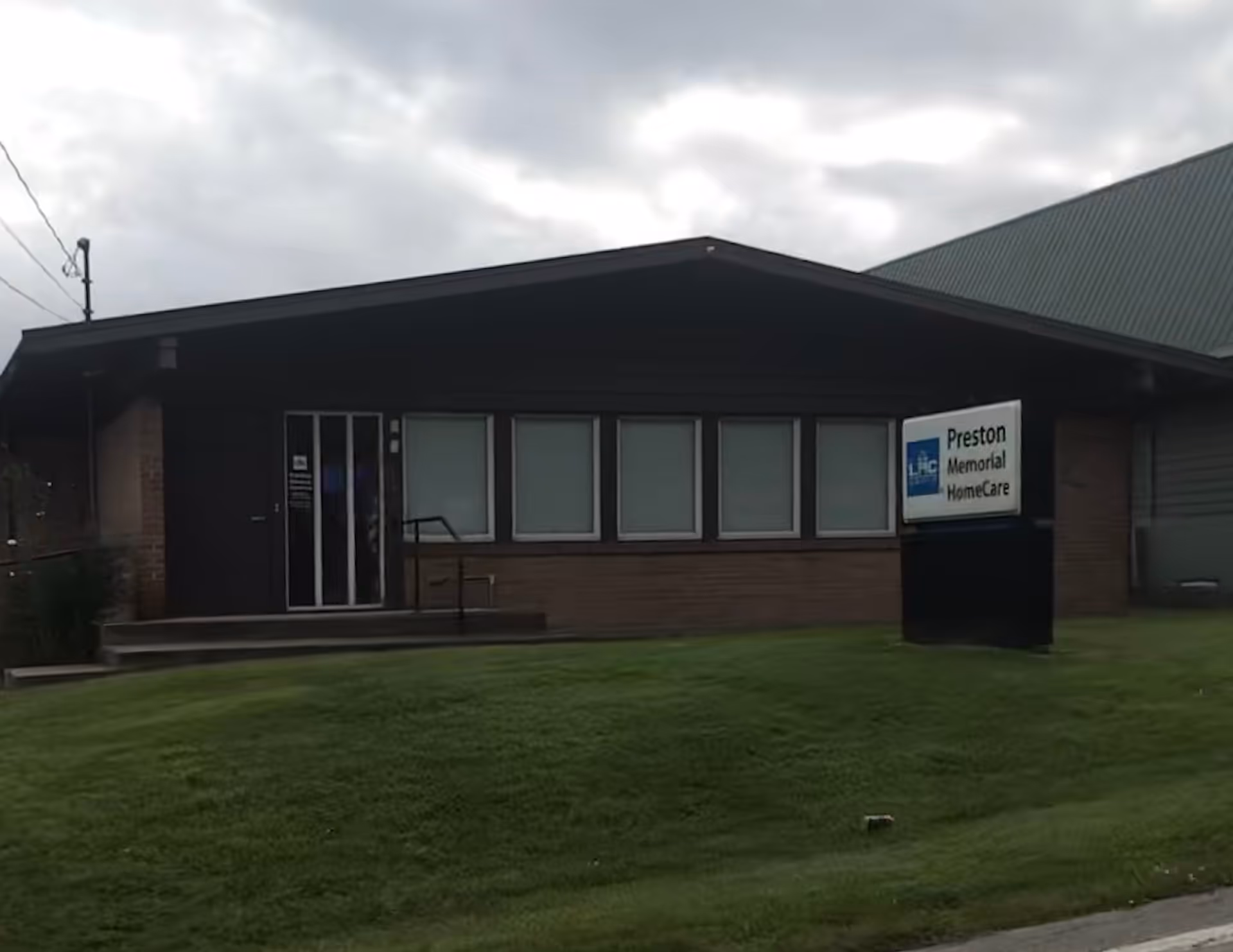Front view of Preston Memorial HomeCare building with a grassy lawn and sign.