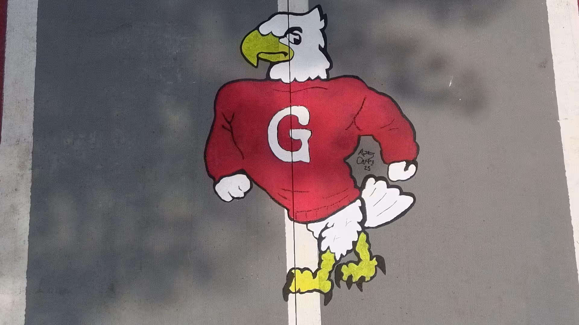 Large mural of an eagle in a red jersey painted on a gray exterior wall.