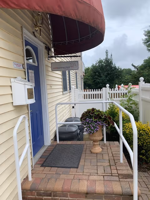 Exterior view of Care Connection Home Care LLC entrance with blue door and ramp.