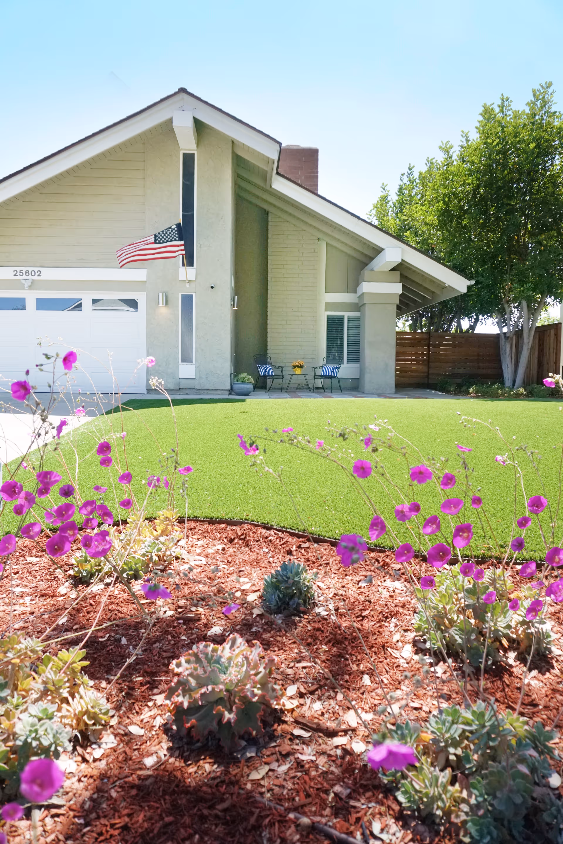 Modern single-story Sacred Heart Senior Care building with lawn, garden, and seating near entrance.