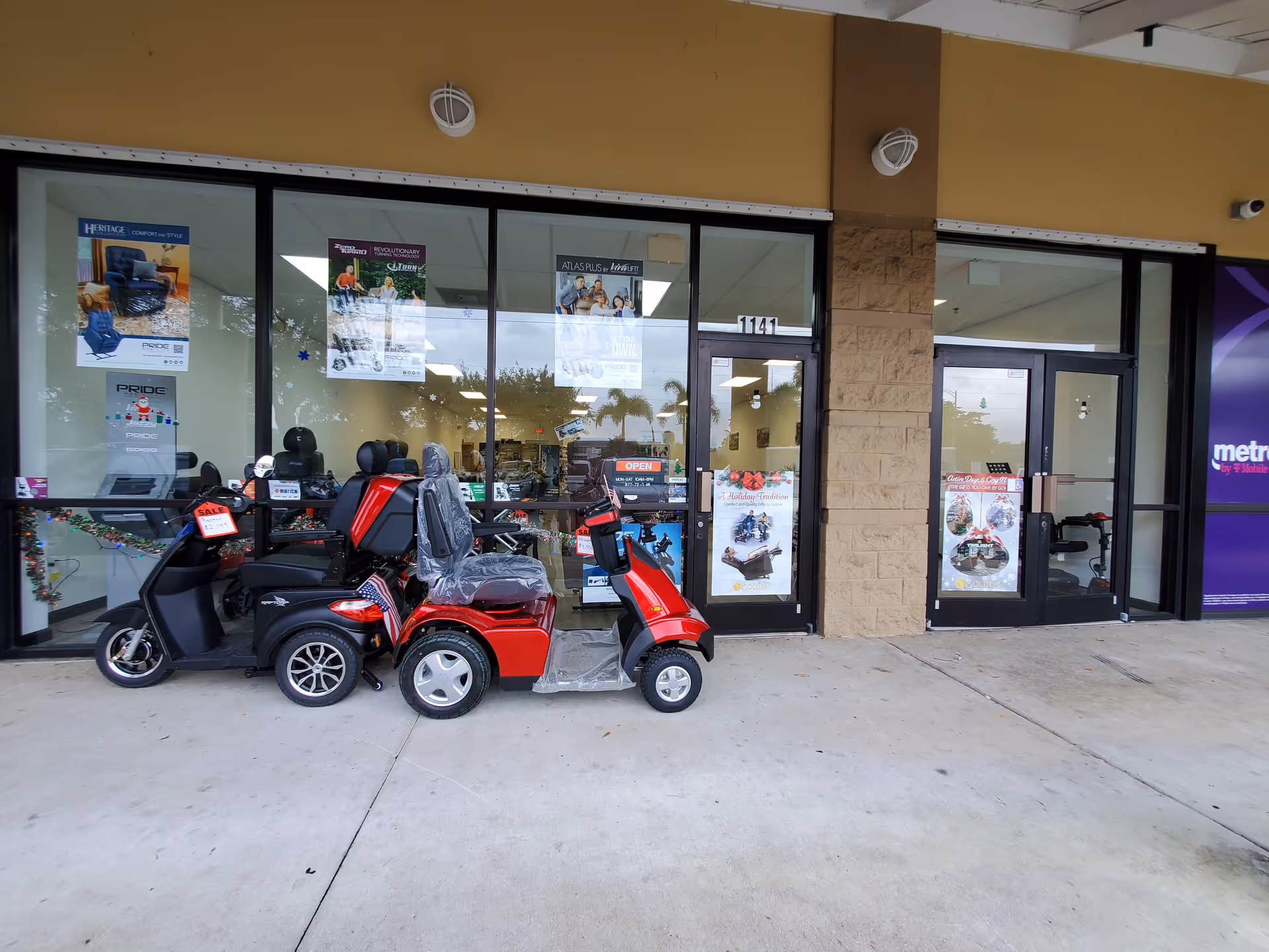 Storefront with glass windows and parked red and black mobility scooters outside