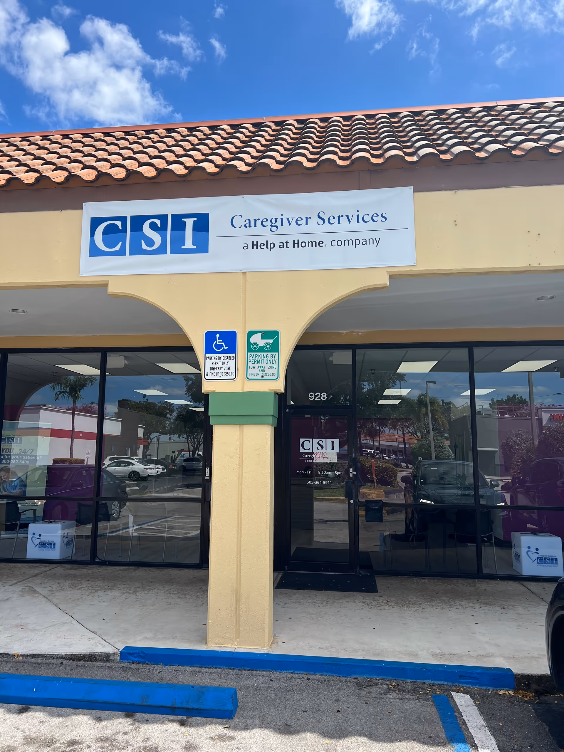 Caregiver Services building front with sign, glass doors, handicap signs, and parking.