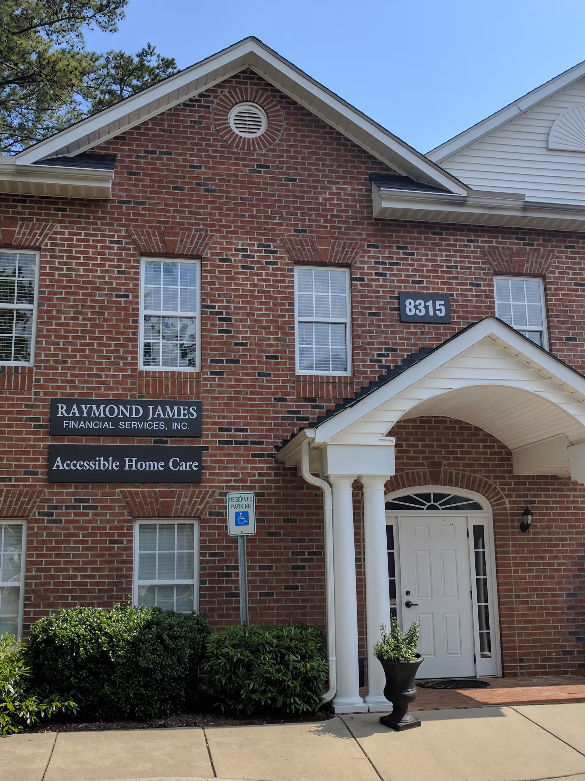 Front of brick building with white entry, accessible doorway, and Accessible Home Care signs.