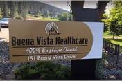An outdoor Buena Vista Healthcare sign with green hills and trees behind.