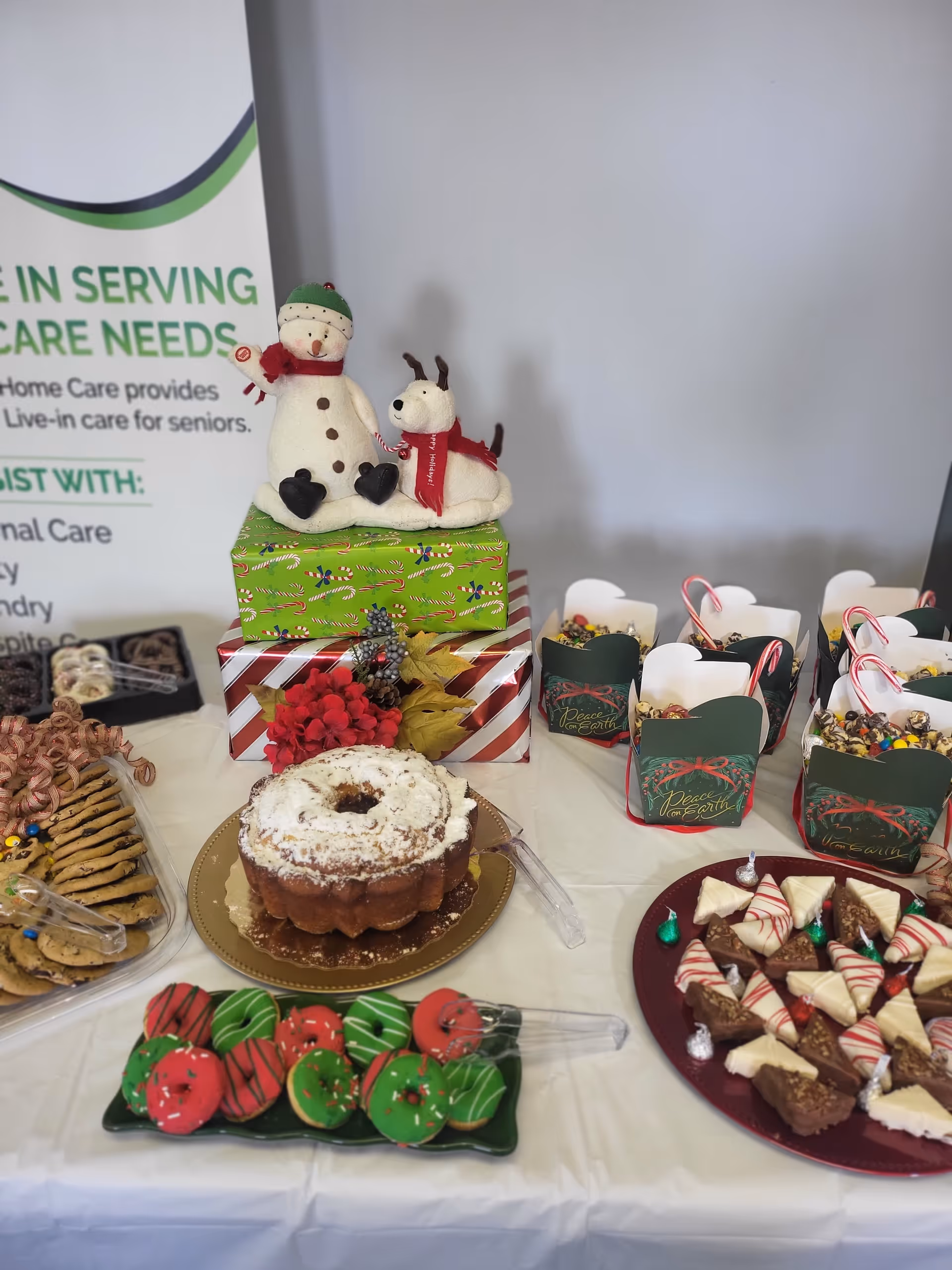 Festive dessert table with cake, treats, and a snowman centerpiece indoors.